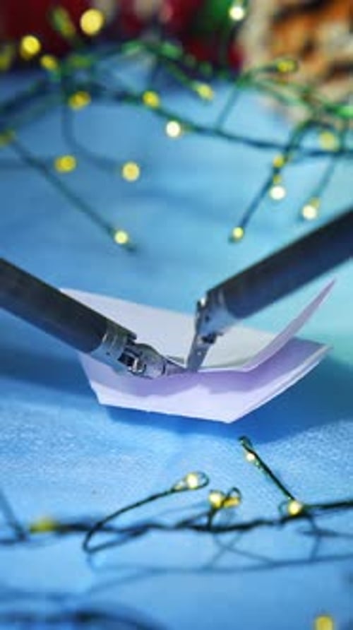 Artificial intelligence robot preparing snowflake from paper while preparing to the Christmas.