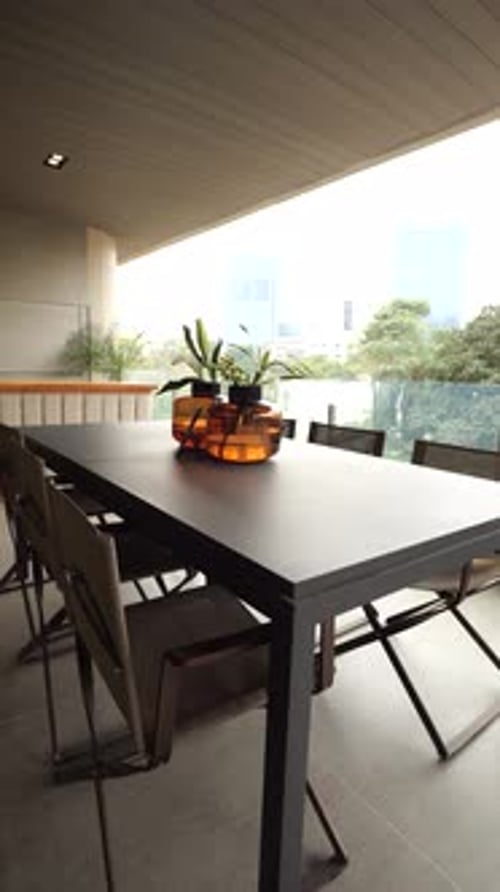 A large table with a view of the city is set for a dinner party