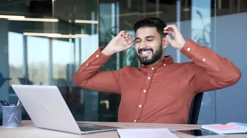 Happy Young Man Working on Laptop in Office