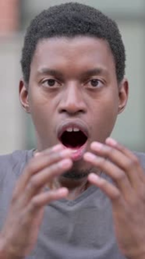 Surprised Young Man Reacting with Shock and Disbelief