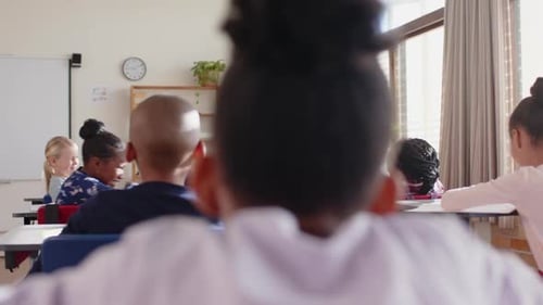 Teaching in school, smiling female teacher engaging with students in classroom