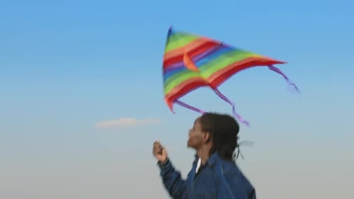 Steadicam eines Afroamerikaners, der Drachen läuft und fliegt