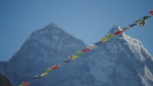 Banderas de oración ondeando contra el monte Everest cubierto de nieve en Dingboche revelan la espiritualidad del Himalaya