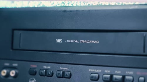 Hand Pressing Eject on Retro VCR Player