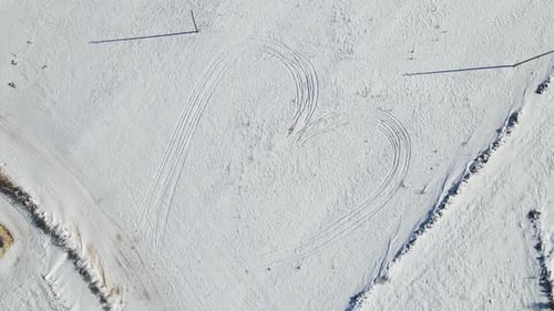Aerial View Heart in Snowy Winter Field