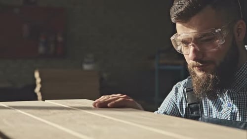 Woodworker Inspecting Planks of Wood Inside Workshop