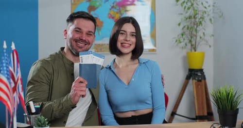 Portrait of a Happy Young Couple in a Travel Agency They are Getting Plane Tickets for a Summer Trip
