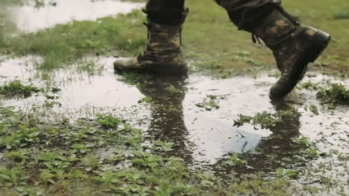 Person Walking Through Puddle Wearing Camo Boots