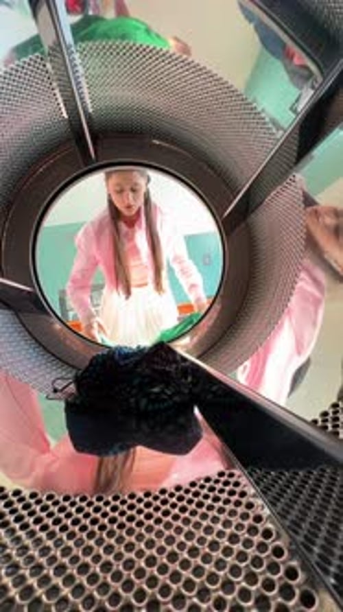 Woman Loading Colorful Clothes into Washing Machine