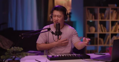 Man Singing and Playing Keyboard at Desk