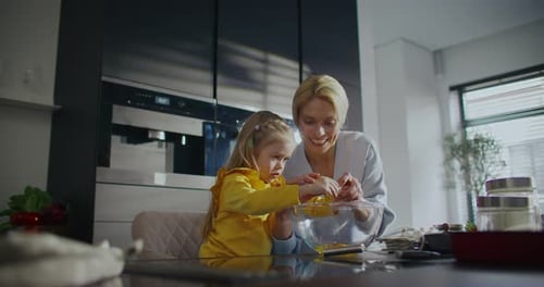 Warm Parenthood Moment Little Girl with Blonde Hair Breaking Egg Shells and Adding Egg Whites to