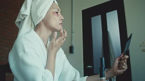 Young Adult Applying Facial Product at Home