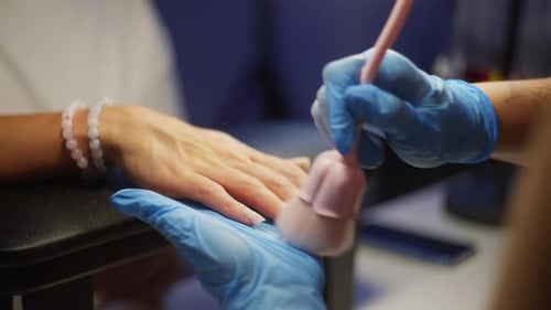 Woman Getting Nails Brushed at Manicure Salon