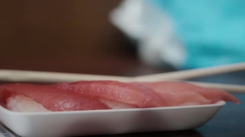 Salmon nigiri sushi with chopsticks close up