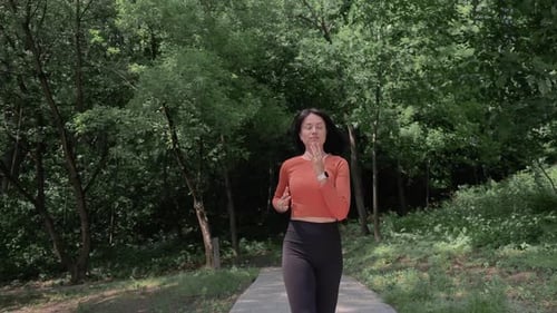 Woman Jogging on Forest Trail in Morning Light Healthy Lifestyle and Mindfulness in Green Natural