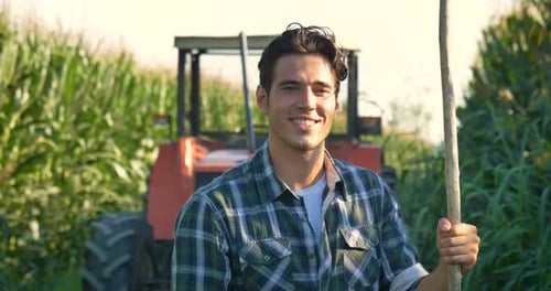Portrait of a beautiful young farmer (student) working in the field with a tractor, successful smi
