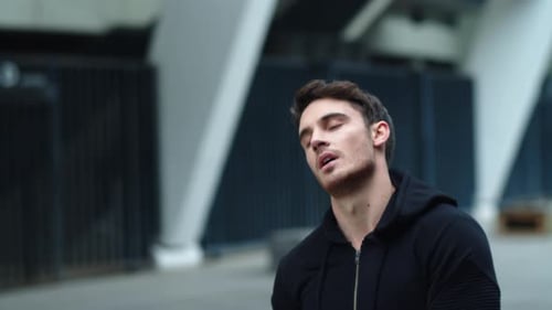 Young man training jump rope exercise on city street in slow motion