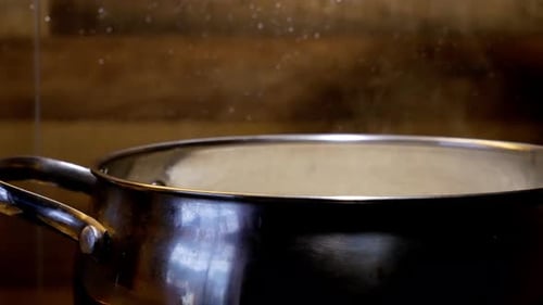 Hand open lid on steaming pot. Home cooking concept.