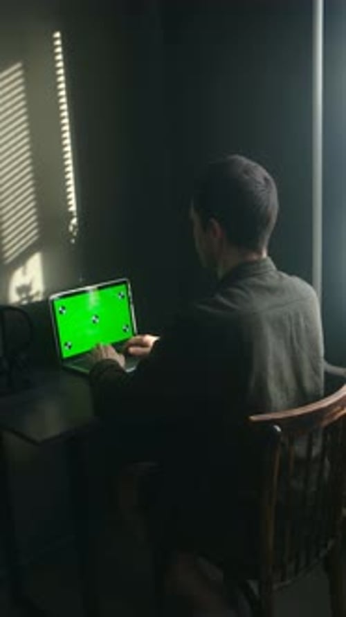 Freelancer Typing on Laptop with Green Screen at Home Office Desk