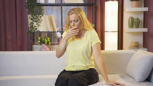 Woman Coughing and Praying on Couch at Home