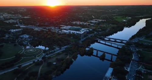 Footage over the Colorado River with bridges above it. Vast green cityscape of Austin, Texas