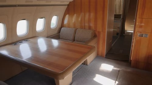 Luxury Airplane Interior Featuring Spacious Lounge Area With Large Table and Natural Light in a