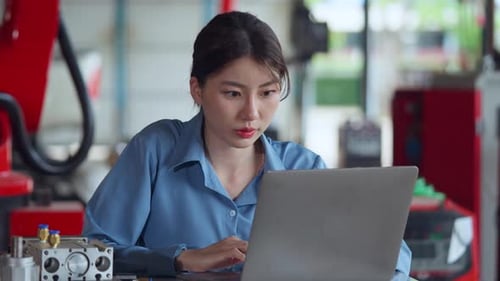 Ingenieurin in blauem Hemd analysiert Daten auf ihrem Laptop