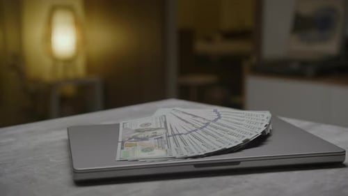 US Dollars on Laptop in Home at Night
