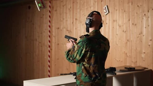 Un soldat joyeux qui s'entraîne avec une arme à feu exulte après avoir touché la cible avec précision
