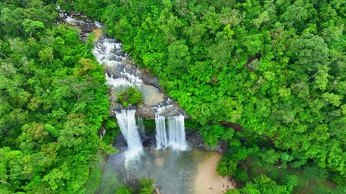 Aerial view over a waterfall in a beautiful tropical forest.