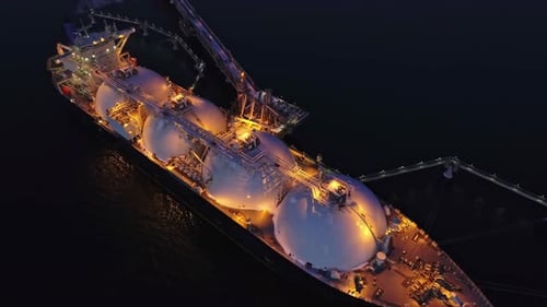 Aerial of Liquified Natural Gas LNG Carrier Moored to a Small Gas Terminal at Night Fuel Crisis