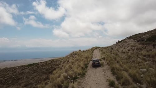 Drone: flies behind a car through a gorge in the mountains of Kyrgyzstan