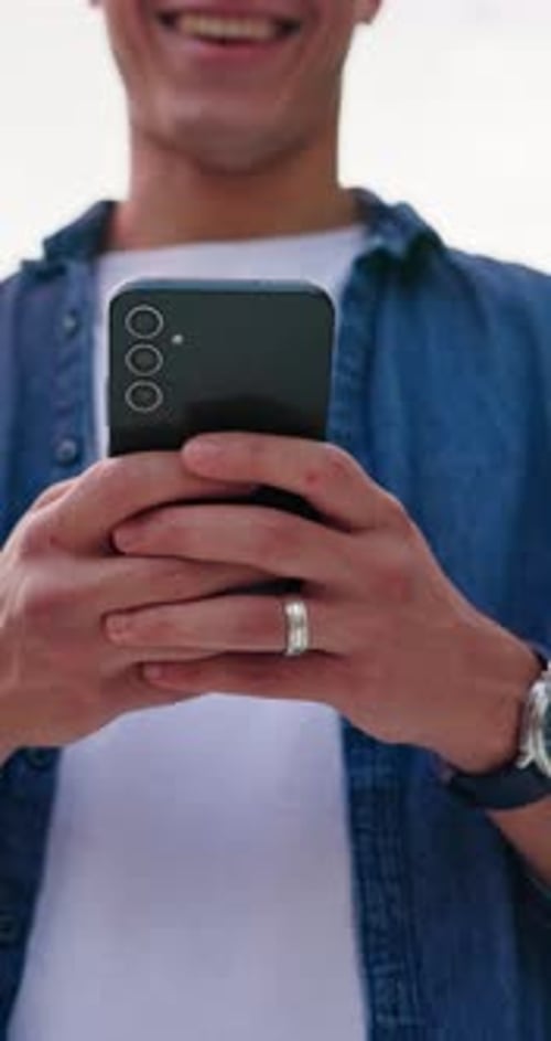 Smiling Man Using Smartphone Device in Urban Setting