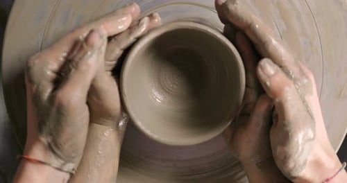 Hands Shaping Clay on Pottery Wheel Close Up