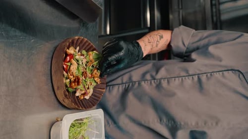 The chef of the restaurant serves freshly prepared salad with chicken vertical video on a plate