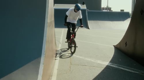 Young BMX Rider Performing Nose Pick Trick at Skate Park
