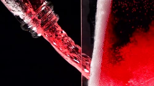 Sauberes Weinglas mit Sektblasenstruktur, sehr Zeitlupe, gefüllt mit trockenem Roséwein