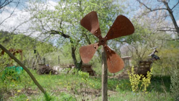 Rusty windmill in a rural garden with blooming trees, Industrial Stock ...