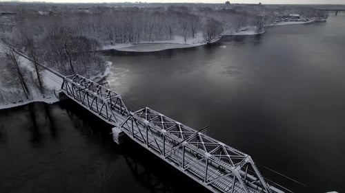 Eisenbahnbrücke über einen gefrorenen Fluss im Winter