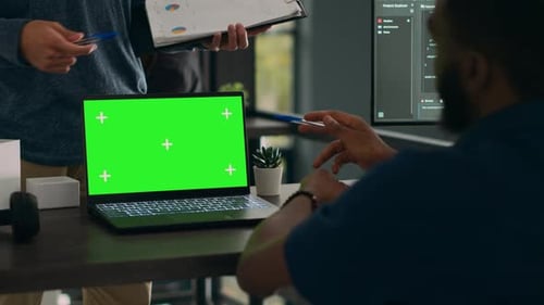 Administradores de banco de dados analisando o código-fonte e a exibição em tela verde no computador