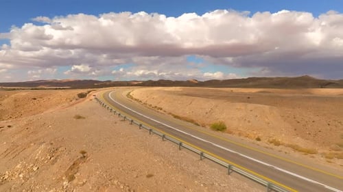 Empty Desert highway mountain road with Blue cloudy sky