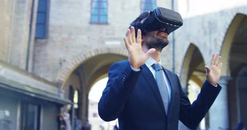 A businessman in a suit uses augmented reality in the city among the people. Concept: immersive te