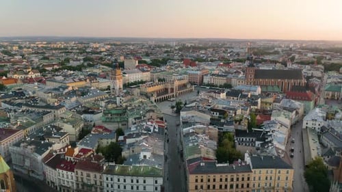 Drone Flies Away from Krakow's Old Town with St. Mary's Church, Town Hall, and Cloth Hall in Backgro