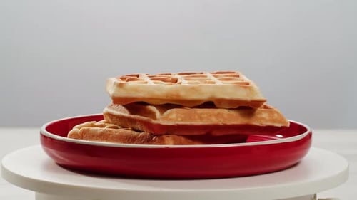 Belgian Waffles Sprinkled with Powdered Sugar with Condensed Milk Top View on a White Background