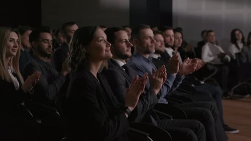 Audience applauds during business presentation at conference