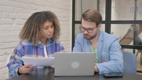 Coworkers Collaborate on a Project in Office