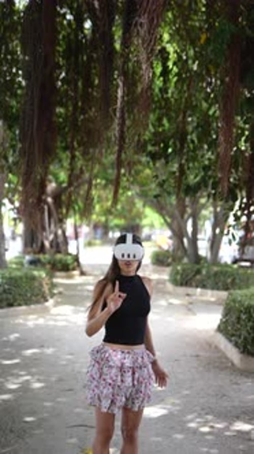A Woman is Using an Advanced ARVR Headset While Immersed in the Charming Outdoor Park Environment