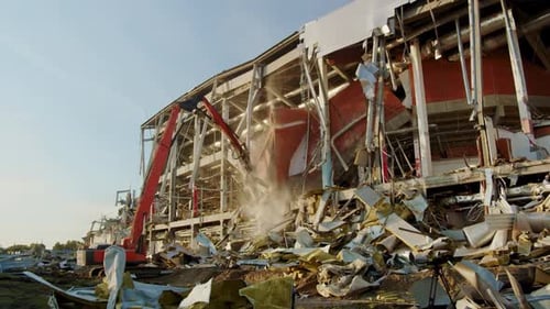 Excavator Destroyer Works on Destroying Hockey Arena in Dust