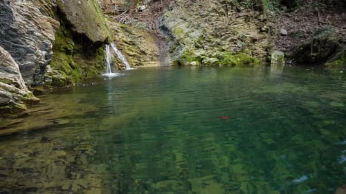 Wide angle video of a small lake creek and a small waterfall