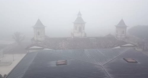 Drone flying over roof of Chateau Cos d'Estournel winery on foggy day, Bordeaux region of France. Ae